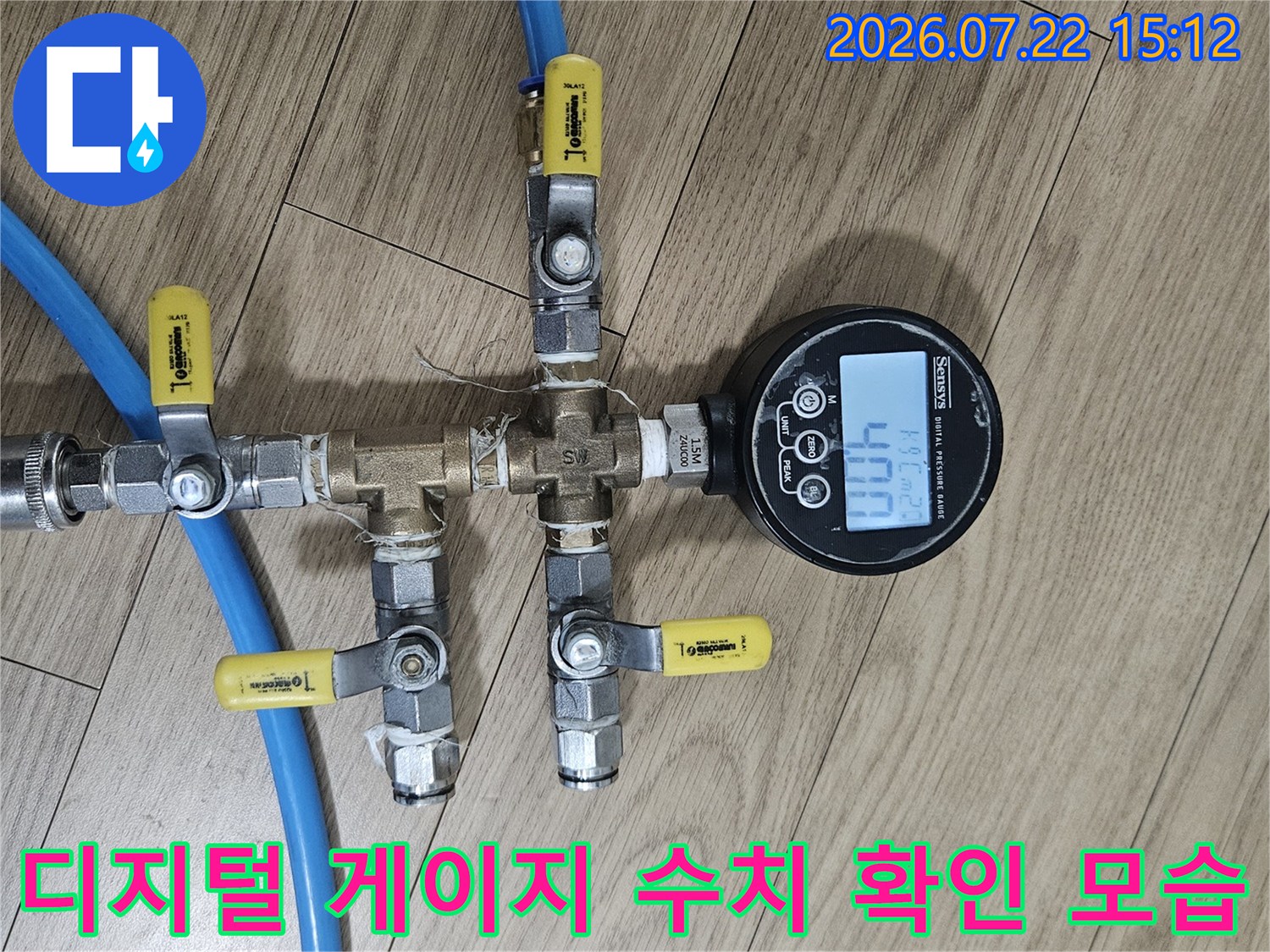 숫자가 표시된 디지털 압력계가 파란색 배관 뭉치 위에 설치된 사진