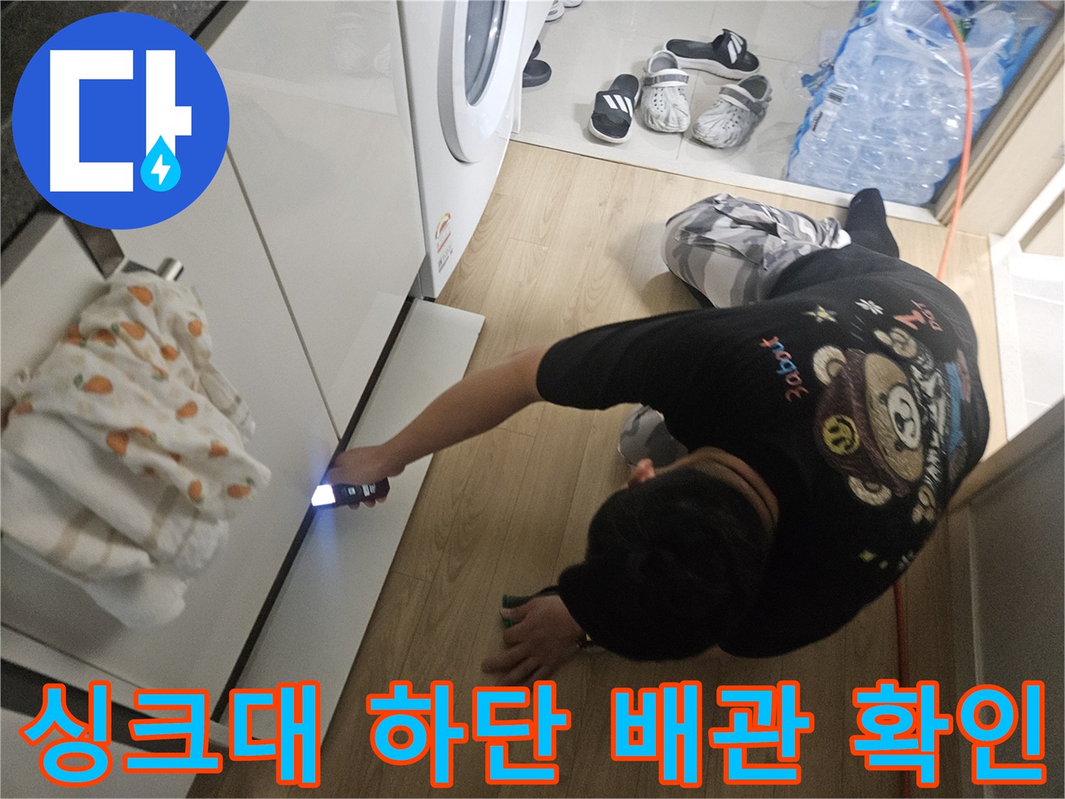 어두운-싱크대-밑-배관-공간을-손전등으로-살피는-엔지니어