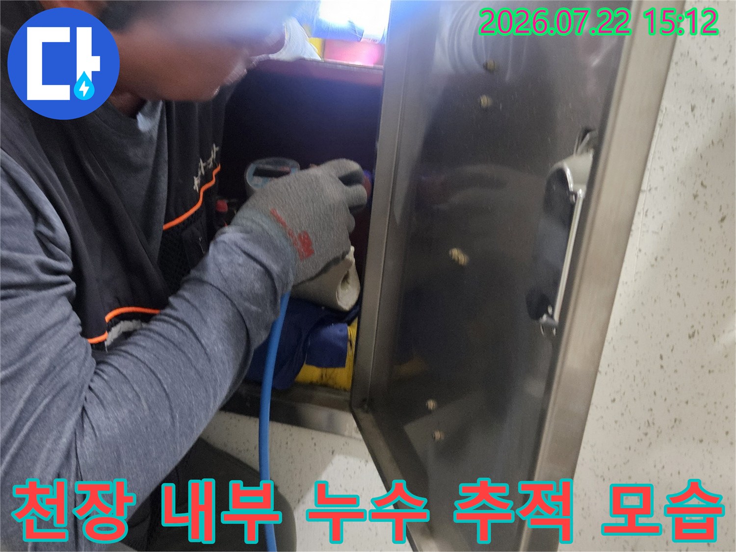 작업자가 좁은 천장 공간에서 탐지 장비를 이용해 누수 지점을 찾는 사진