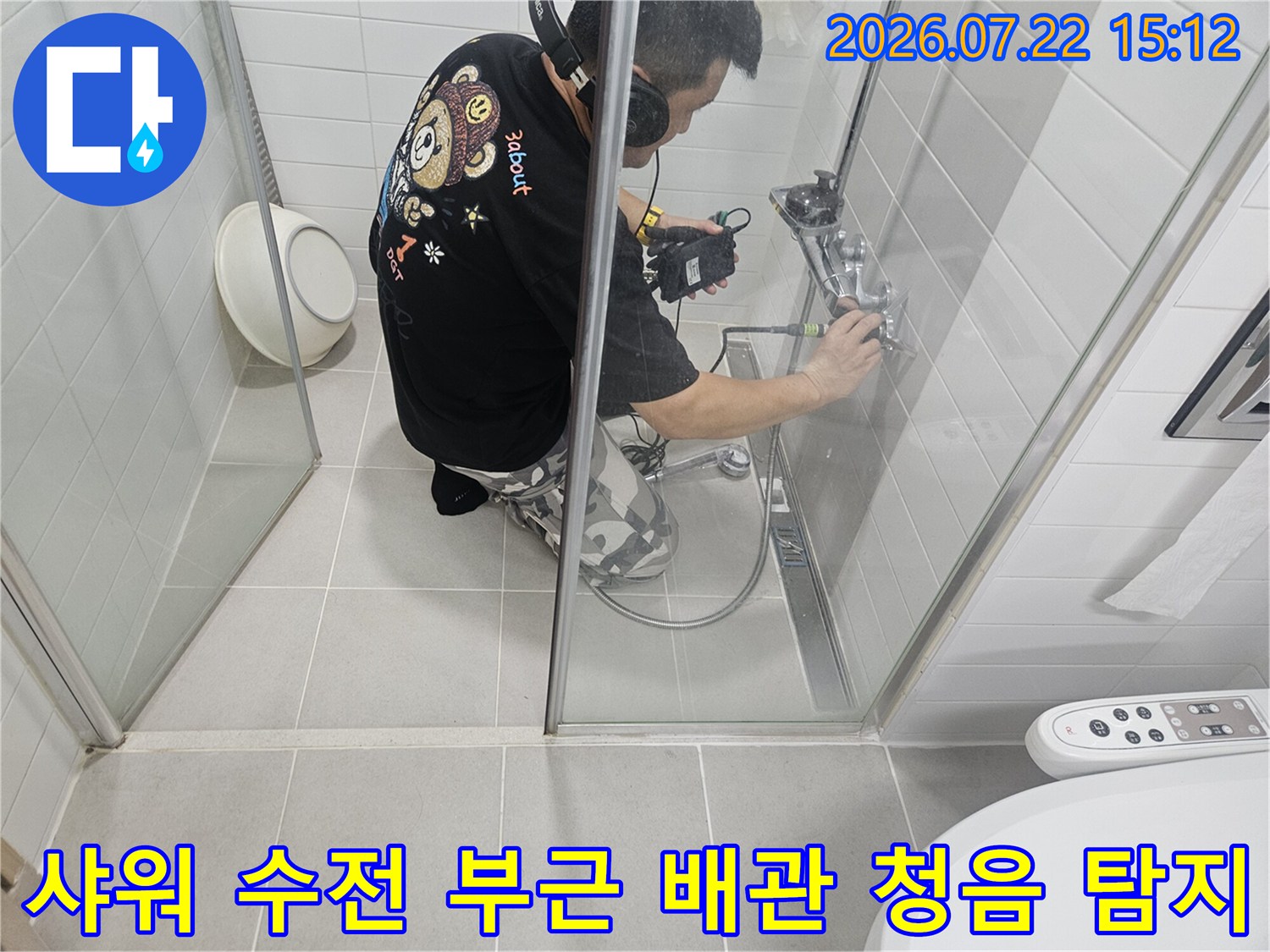 화장실-내부에서-청음식-탐지기를-벽면에-밀착시켜-누수음을-확인하고-있는-작업자의-모습