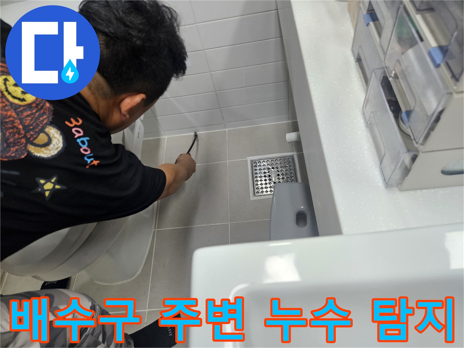 화장실 배수구 근처의 타일 틈새를 엔지니어가 면밀하게 조사하고 있습니다.