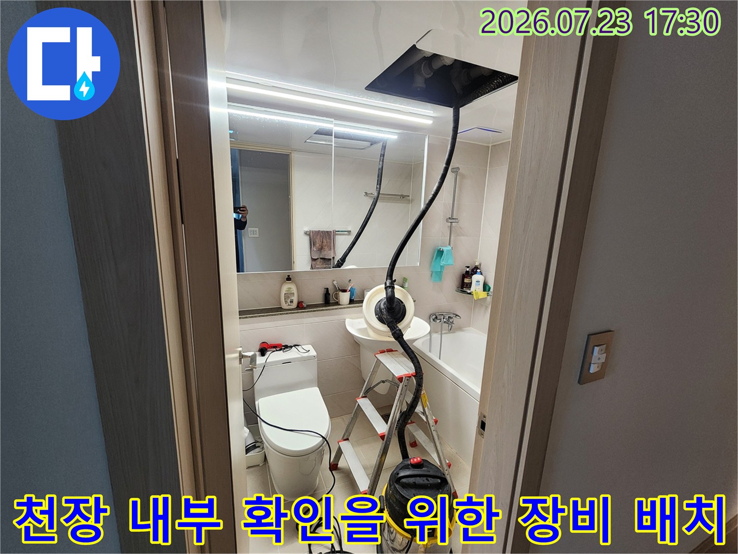 화장실 변기와 세면대 옆에 설치된 사다리와 천장 점검용 검은색 패널-집진기 연결 상태