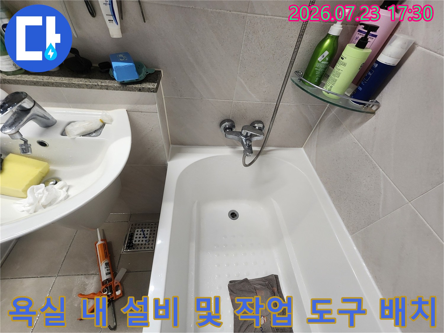 흰색-세면대와-욕조가-설치된-화장실에-작업용-플라이어가-놓여있는-모습