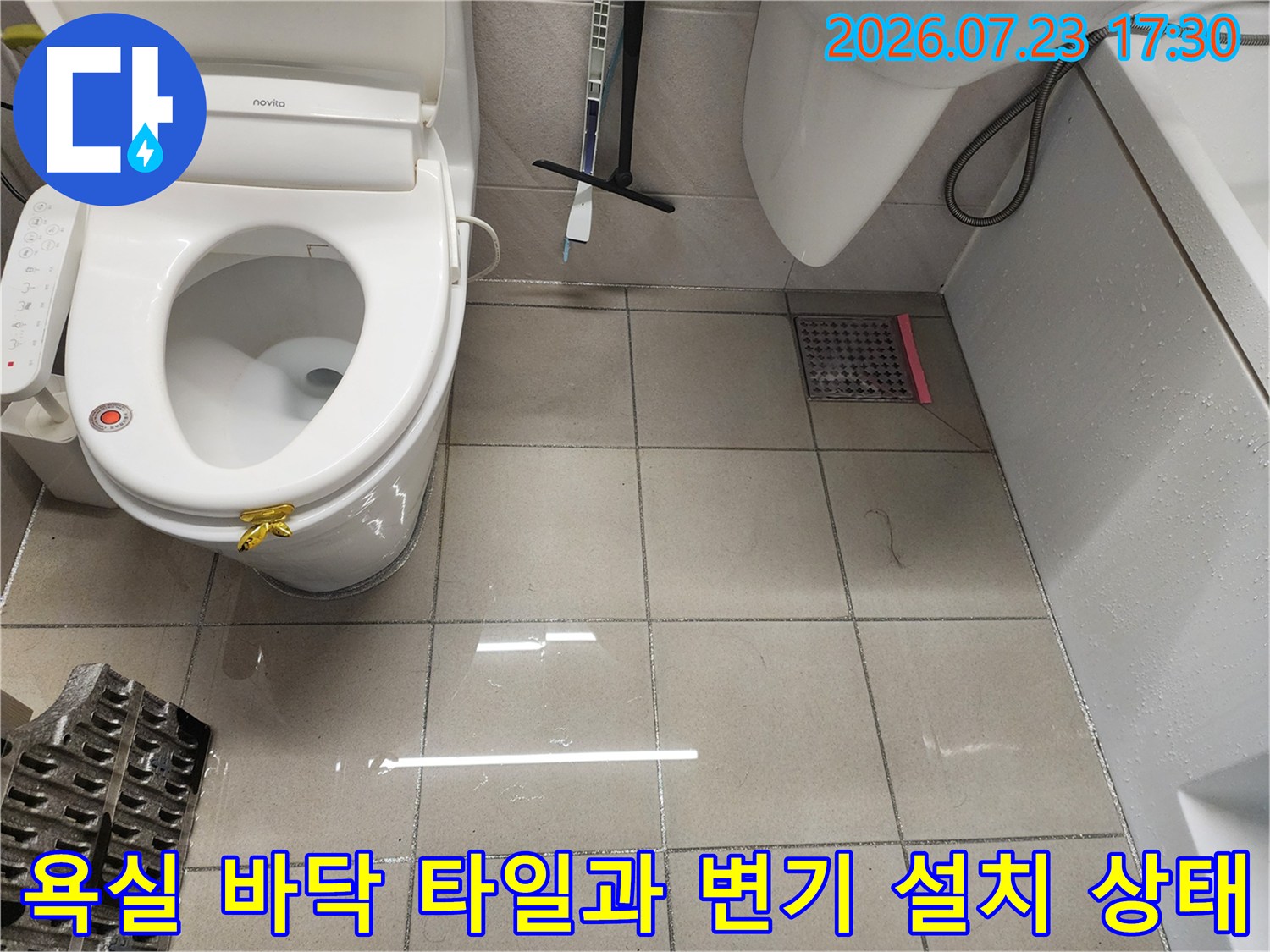 흰색 유광 타일이 시공된 화장실 내부의 변기와 배수구-점검 대상