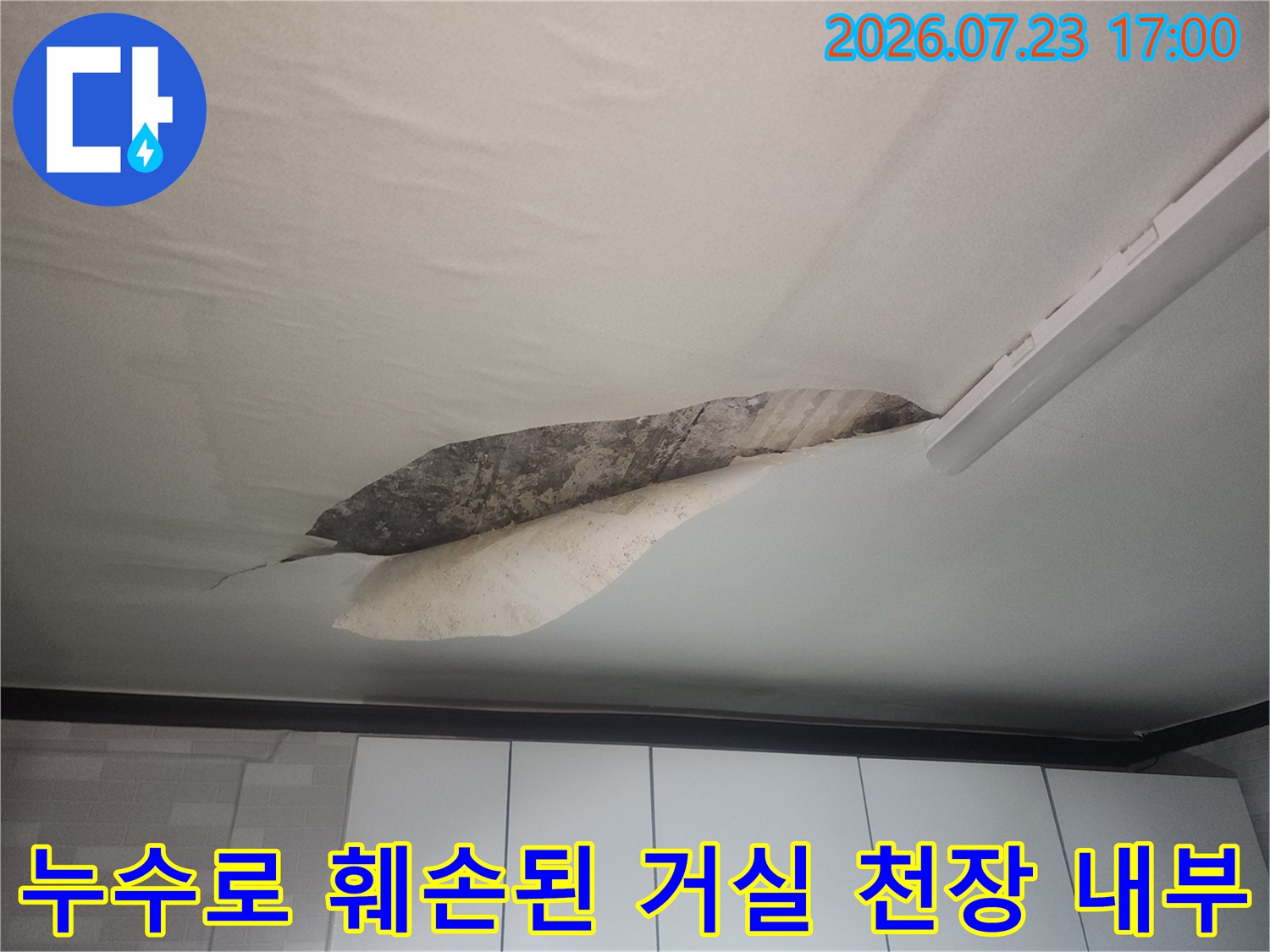 물에 젖어 늘어진 천장 벽지와 그 사이로 보이는 어두운 색의 콘크리트 천장면