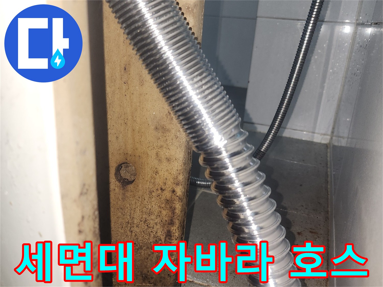 세면대 하단 은색 금속 주름관과 벽체 연결부 모습