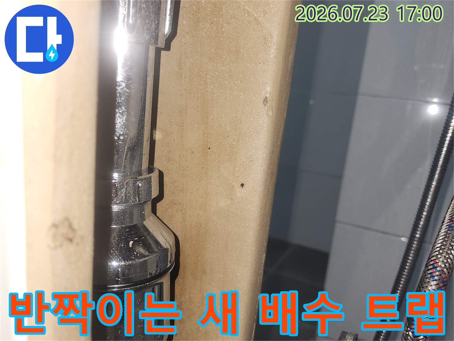 은색 금속 재질의 배수 트랩과 주름관이 연결된-하수도 배관 사진