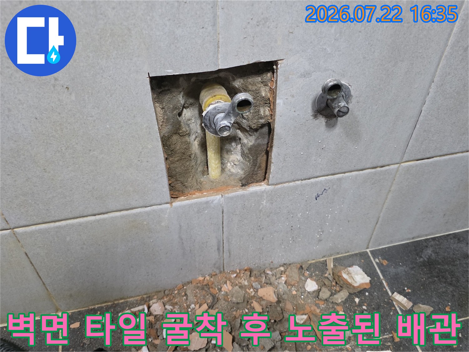 성북구 정릉동 현장에서-타일을 일부 제거하고 벽 속에 매립된 노란색 수도 배관을 찾아낸 모습
