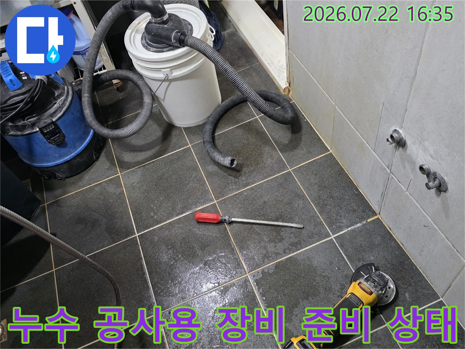 타일 바닥에-나란히 놓인-습식 청소기와-전동 공구들-및 수공구