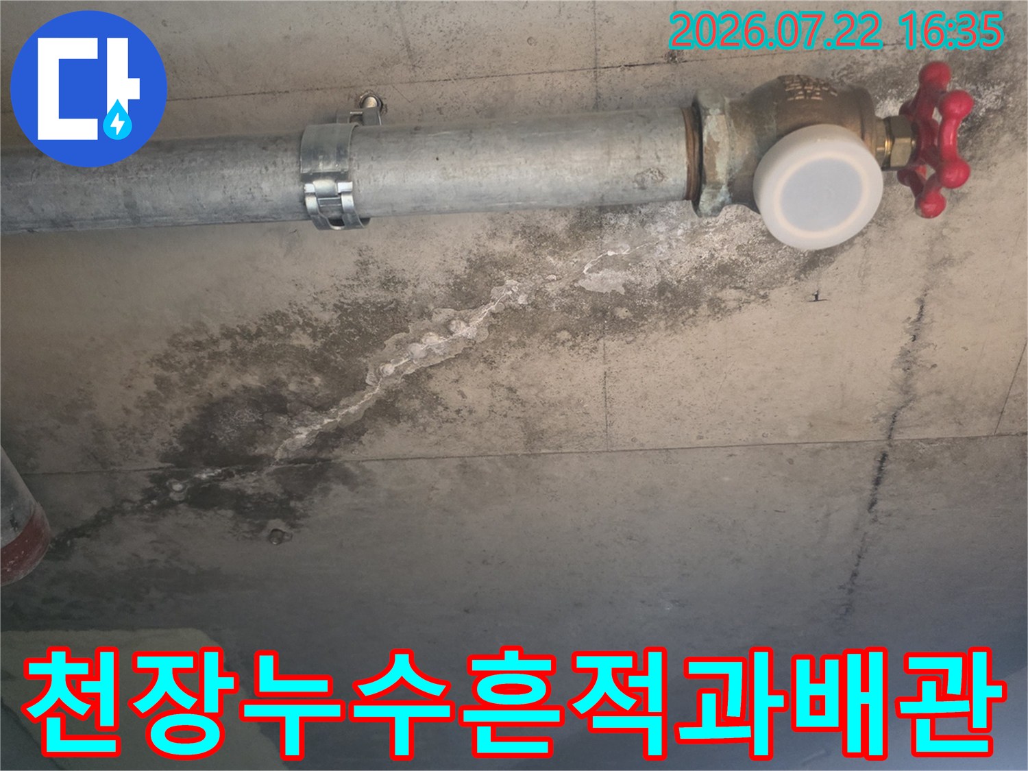 회색 콘크리트 천장에-설치된 배관과 넓게 퍼진 어두운 색의 물자국