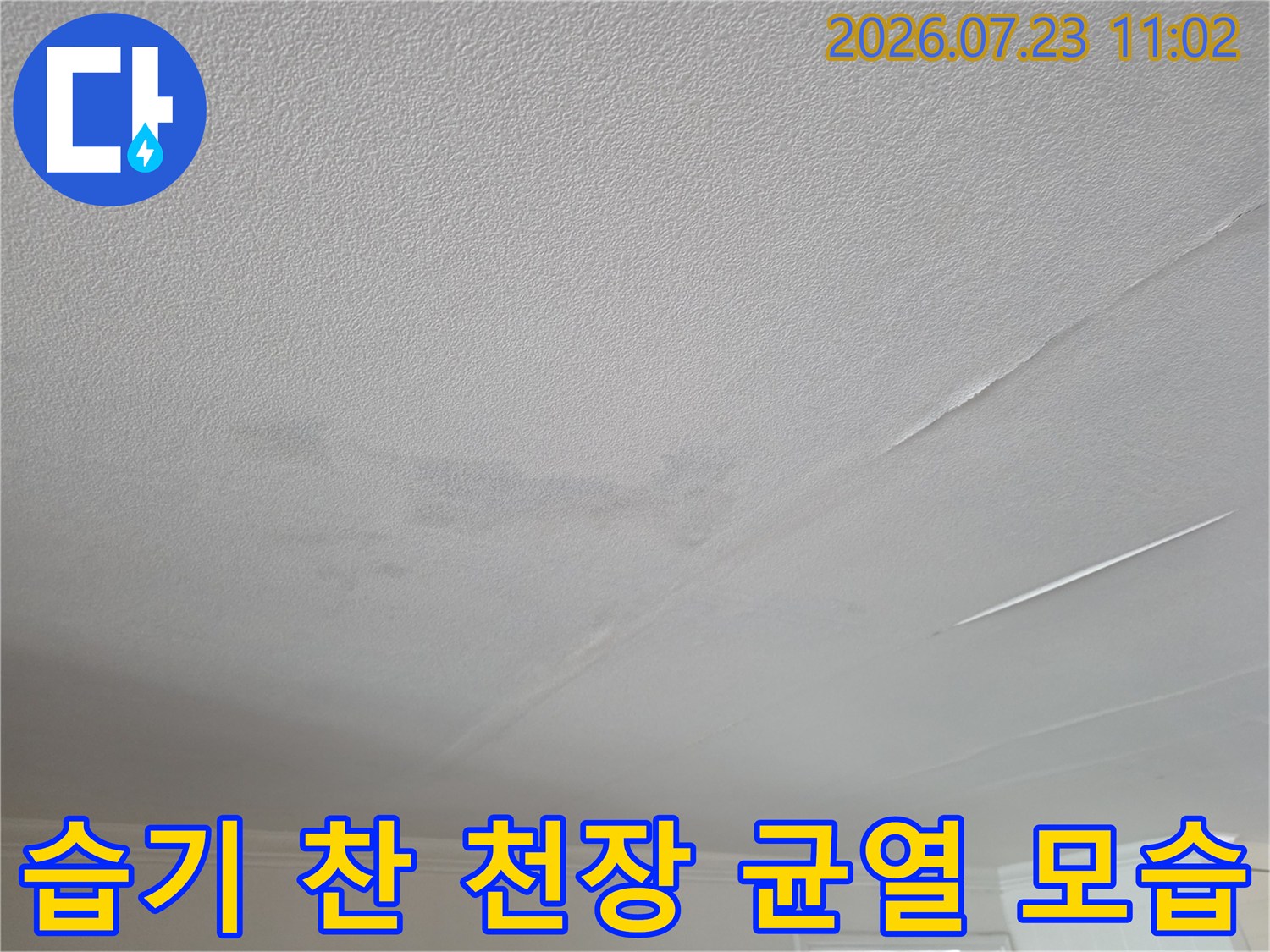 천장의 직선형 갈라짐-그리고 그 주변으로 번진 누수성 습기 얼룩