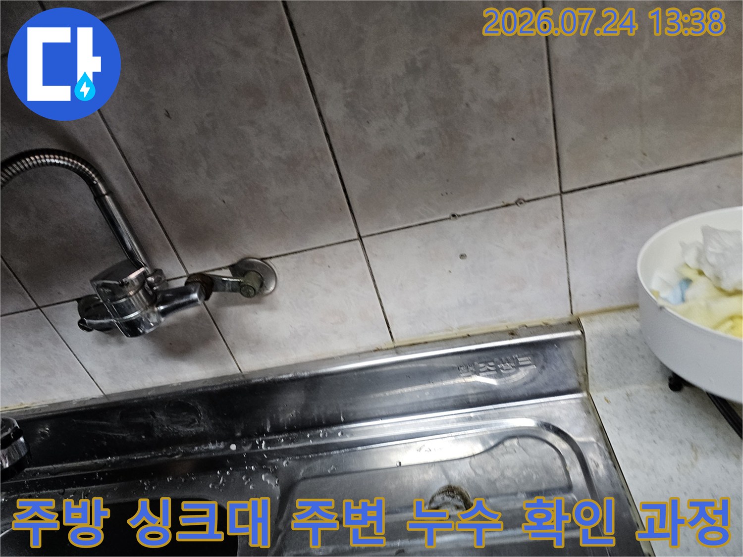 금속 재질의 주방 싱크대 상판과 벽면-그리고 설치된 수도꼭지의 전경