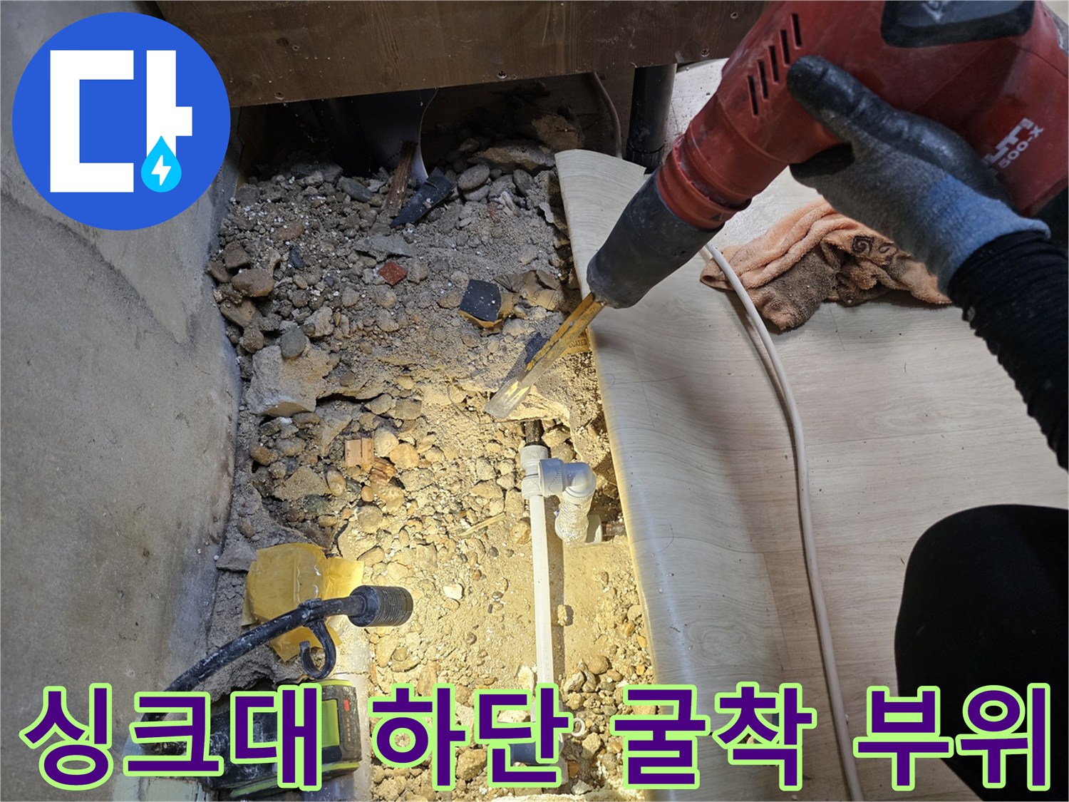 바닥을 파낸 후 드러난 배관과 주변의 자갈 및 시멘트 조각들