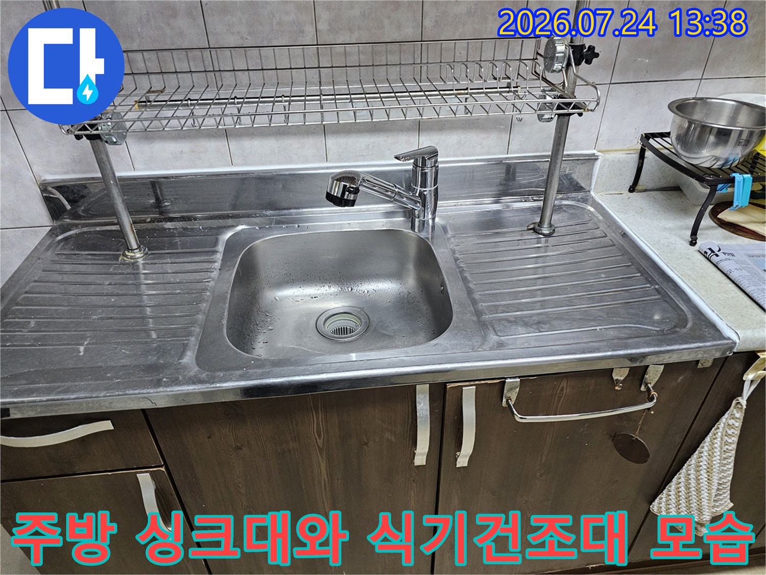 스테인리스 소재의 주방 싱크대-상단에 금속제 식기건조대가 설치된 모습