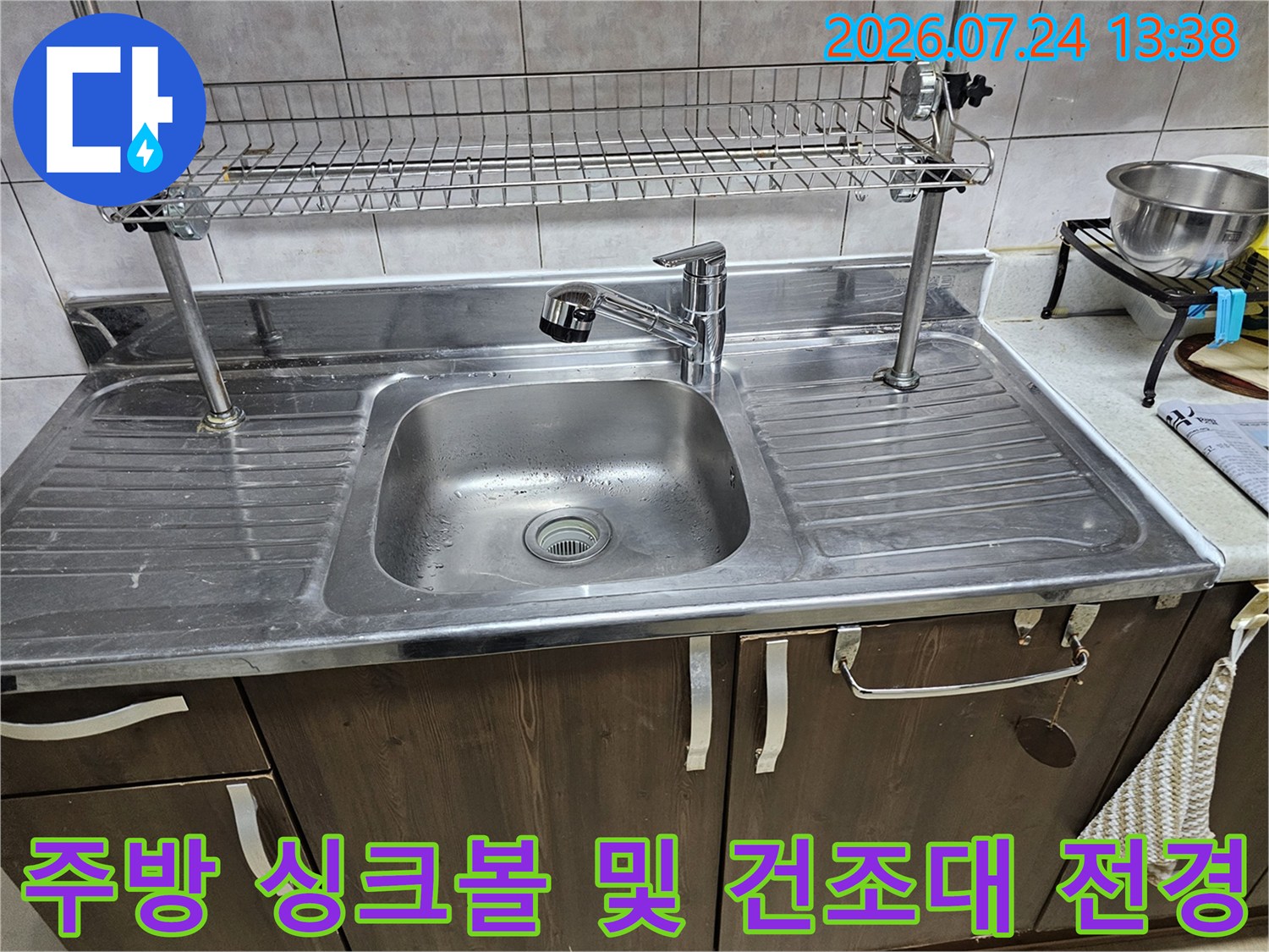 은색 광택의 스테인리스 싱크대와 수전 그리고 상단 식기 거치대