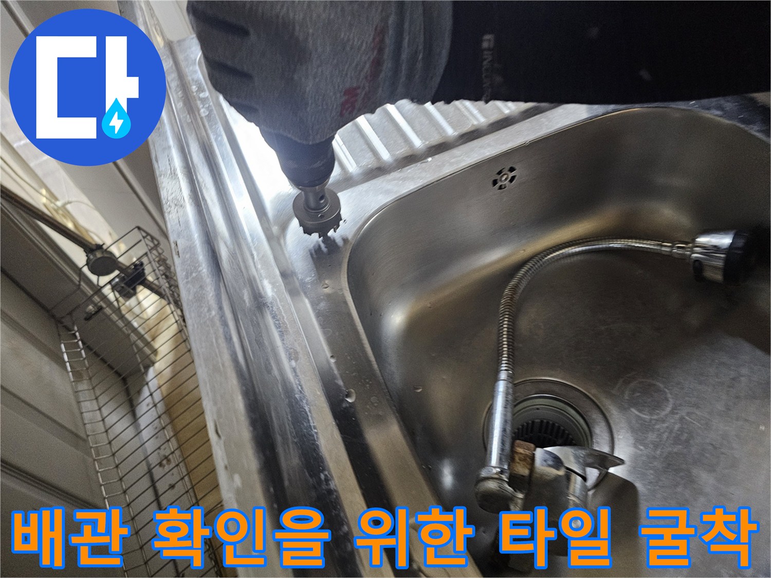 주방 싱크대 하단-배관 파손 부위를 찾기 위해 드릴로 타일을 깨는 모습