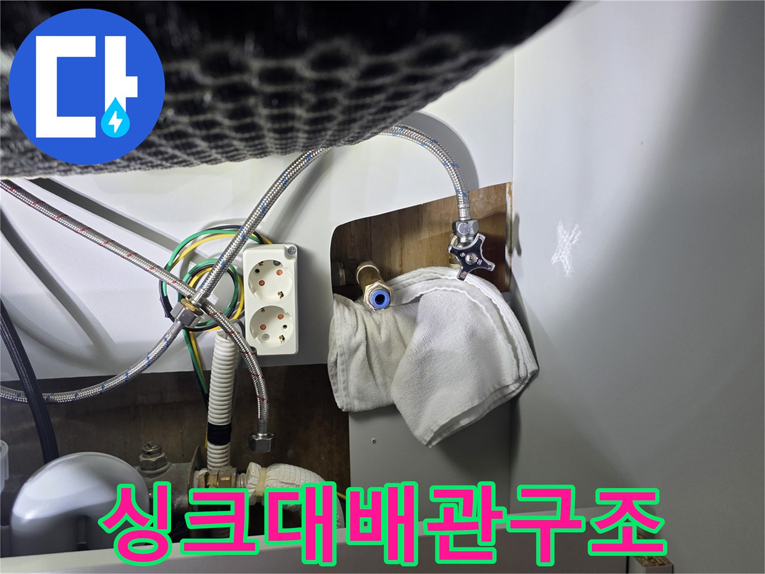 싱크대-하부장-내부의-복잡한-수도-배관과-전기-콘센트-노출