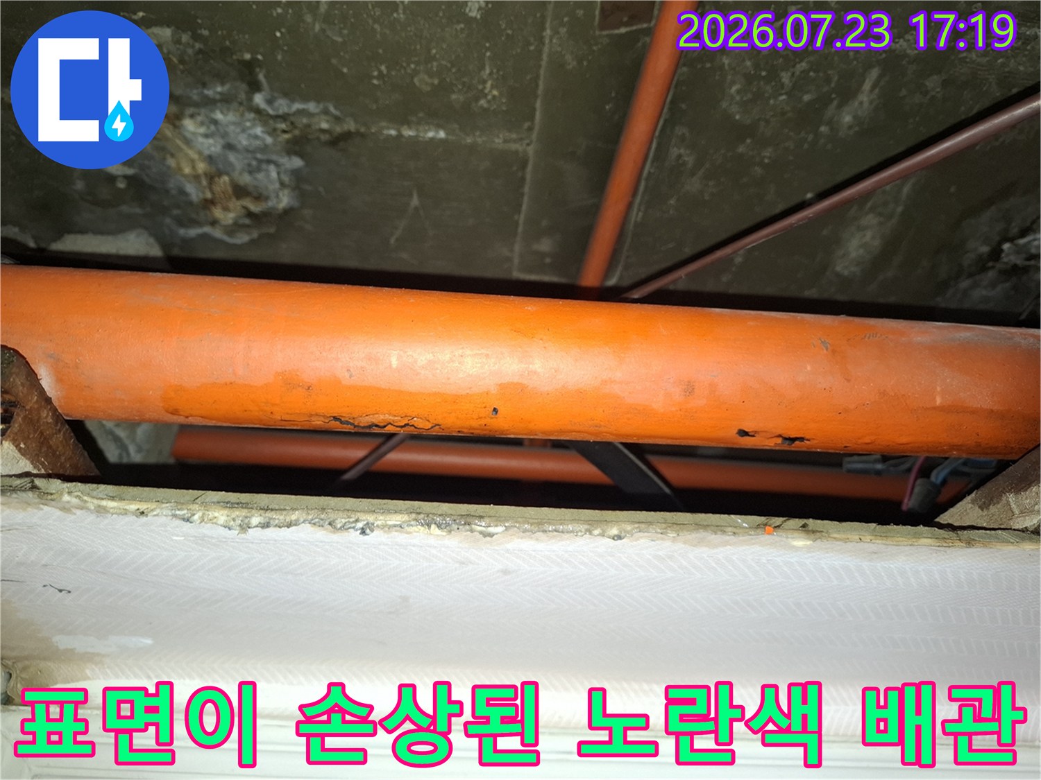 심한 부식으로 인해 표면이 울퉁불퉁하게 변형된 오렌지색 누수 배관 사진