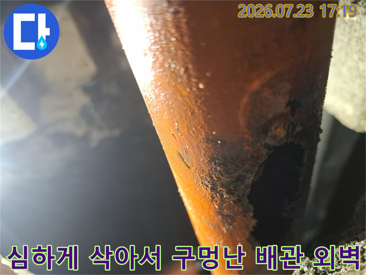 오렌지색 배관의 표면이 부식되어 커다란 파손 구멍이 생긴 모습