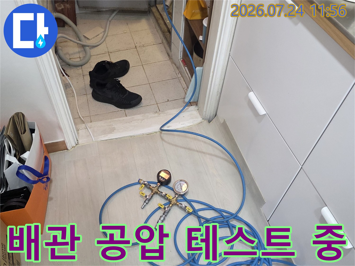 파란색 배관에 연결된 압력계와 호스를 이용한 누수 점검 장면