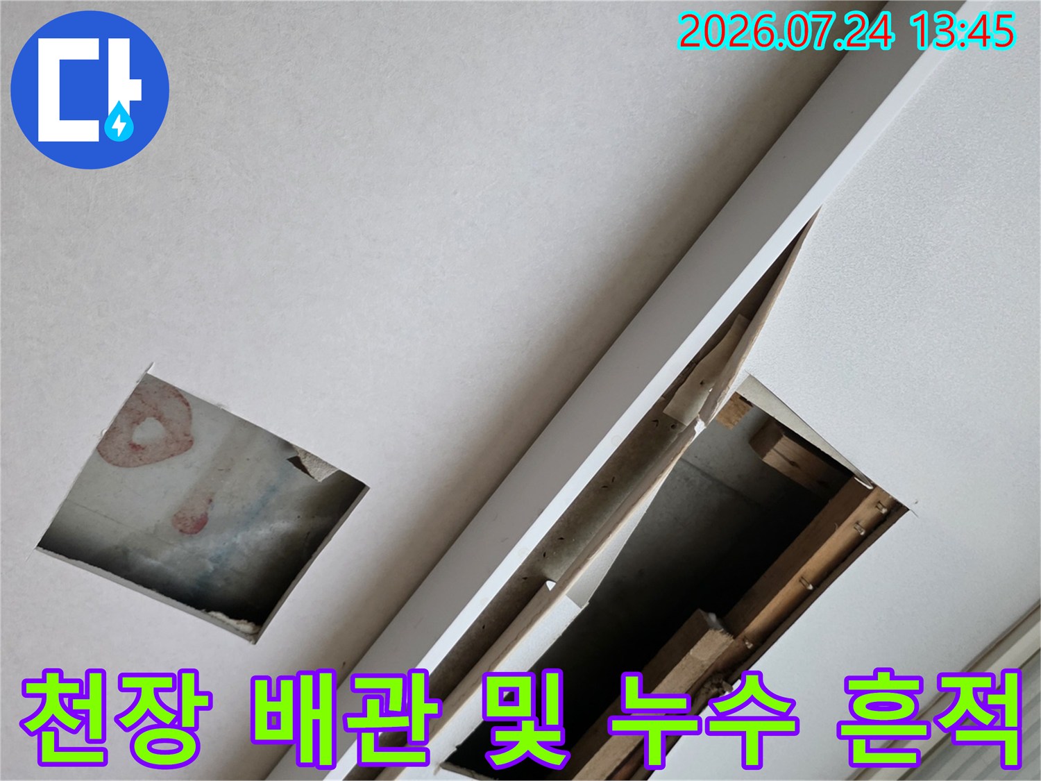 거실 천장 안쪽의 습기 얼룩과 노출된 배관 상태를 점검하는 모습