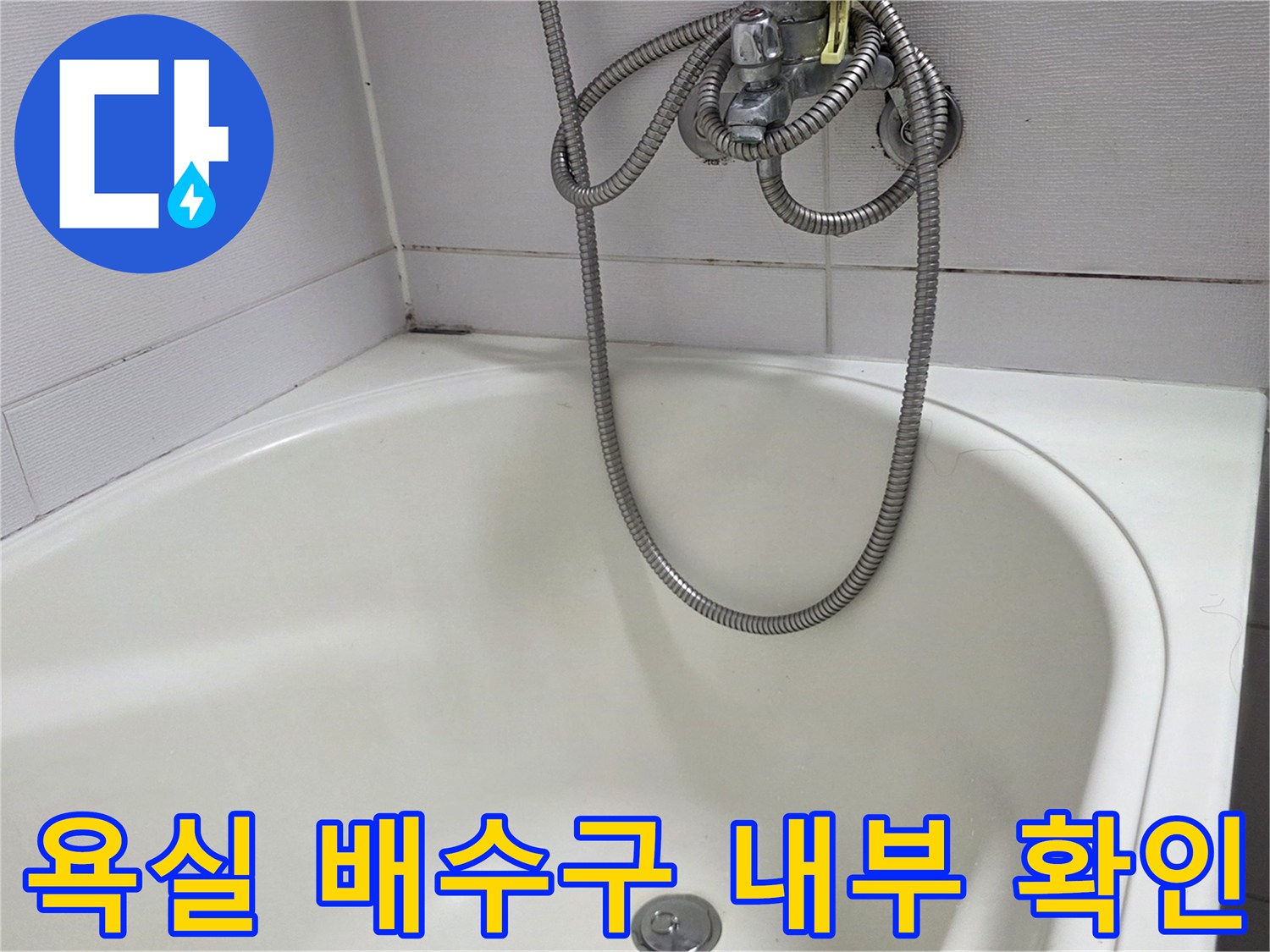 하얀색 욕조 바닥의 배수구와 금속 샤워 호스