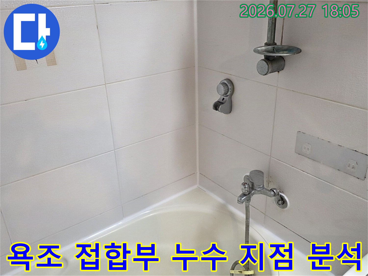 흰색 타일 벽면에 샤워 수전이 부착되어 있고 하단에 욕조가 배치된 모습