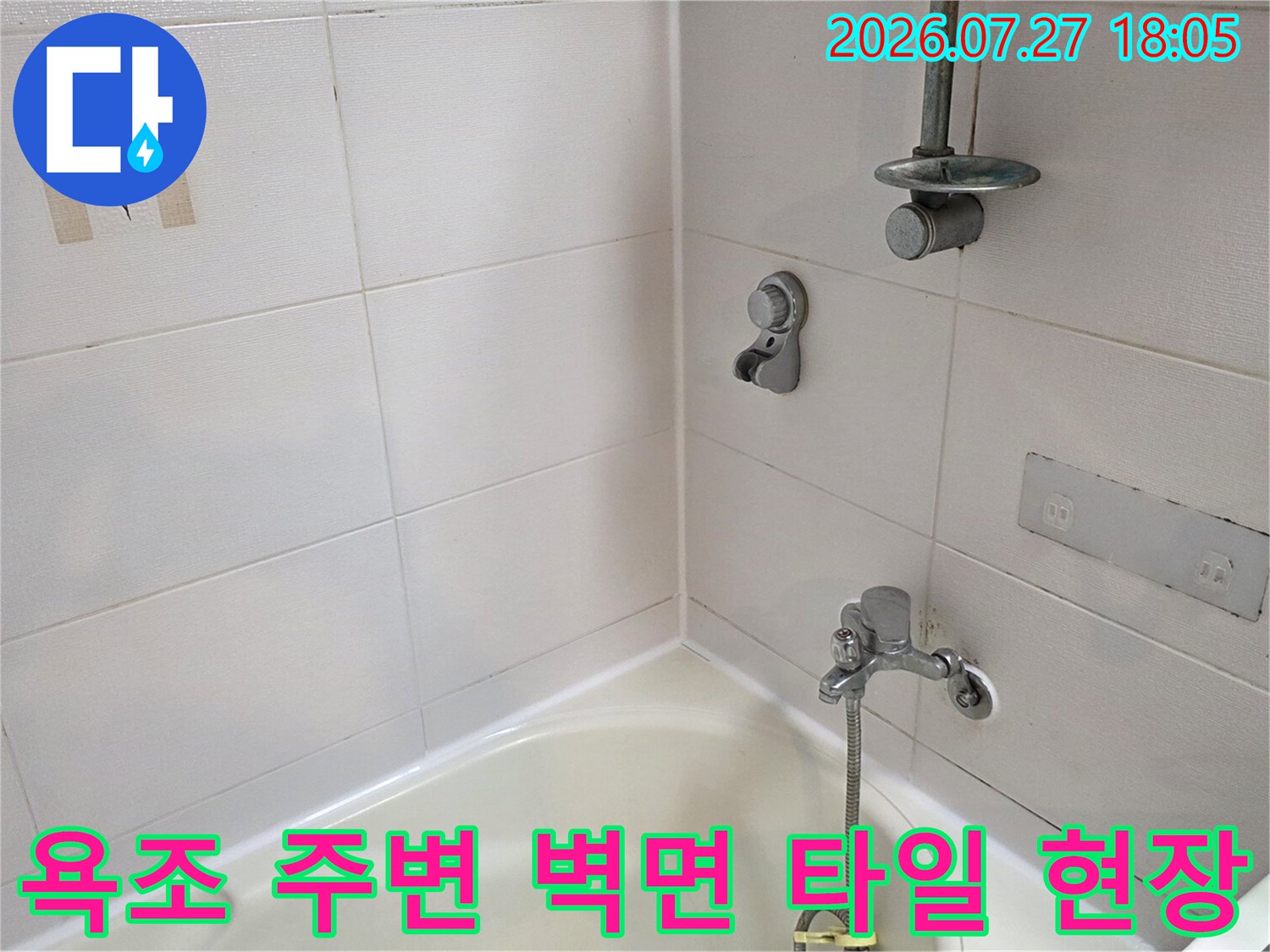 흰색 타일이 시공된-욕실 내부의 샤워기 수전과 욕조 모서리 부분