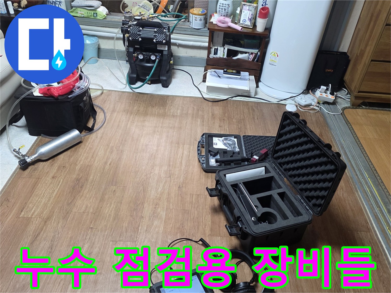 현장 바닥에 놓인 가스 탐지기와 청음식 진단 기기 세트입니다.