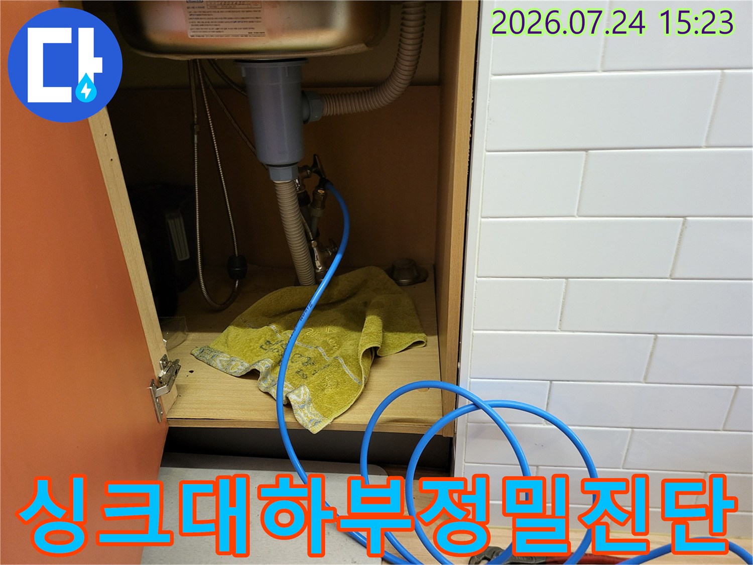 싱크대-하단-배관에-연결된-파란색-측정용-호스와-작업-도구