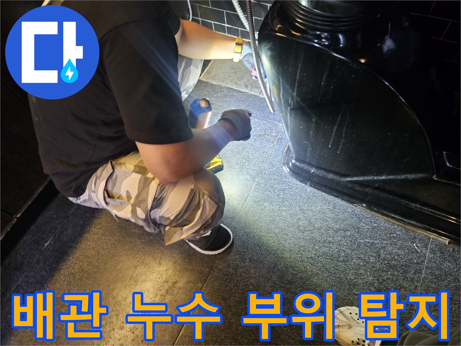 어두운 샴푸대 하단-배관 누수 지점을 찾는 작업 현장