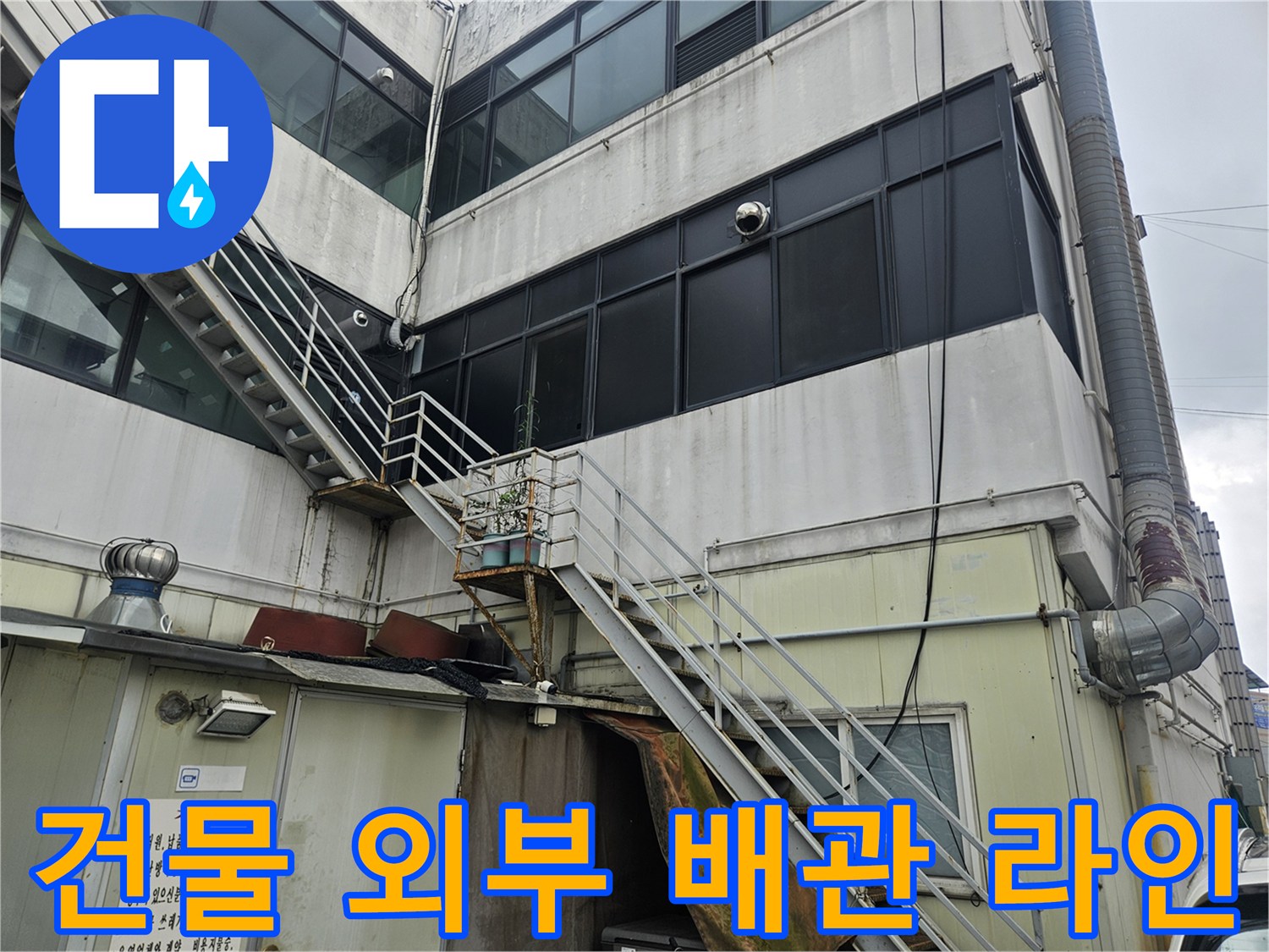 외벽에 설치된 수직 배관과 금속 난간의 상세 모습