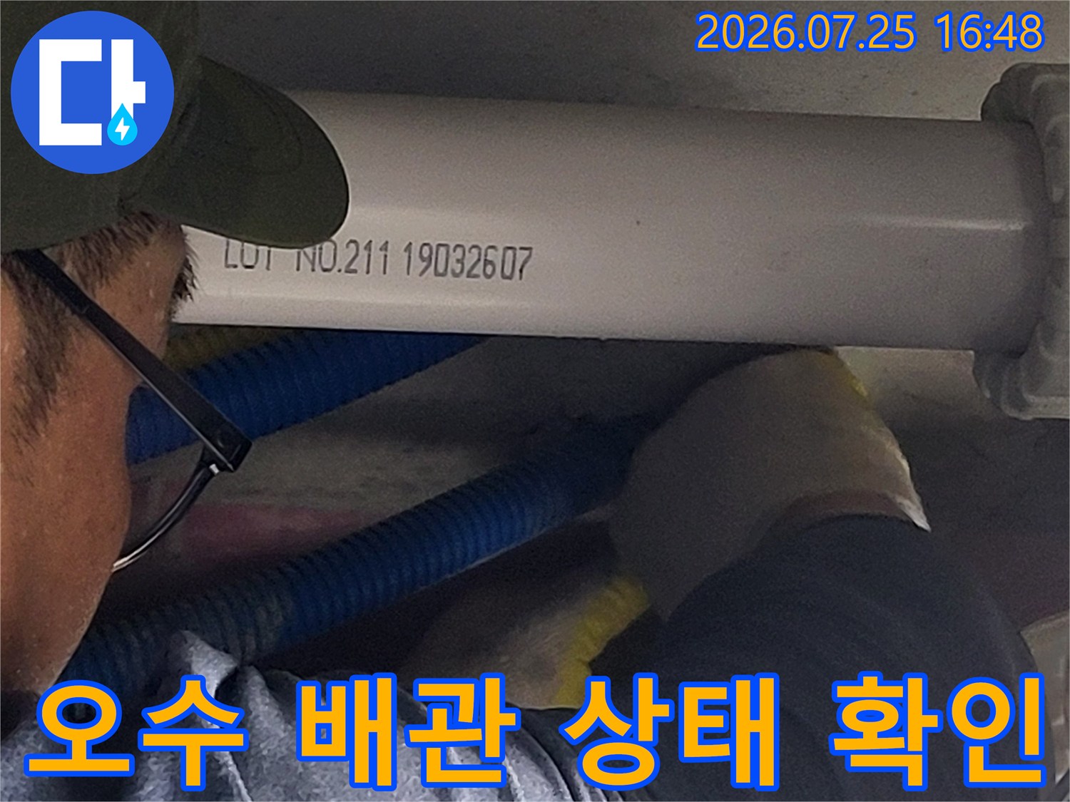 작업자가 장갑을 끼고 수직으로 설치된 흰색 오수 배관의 이상 유무를 점검함