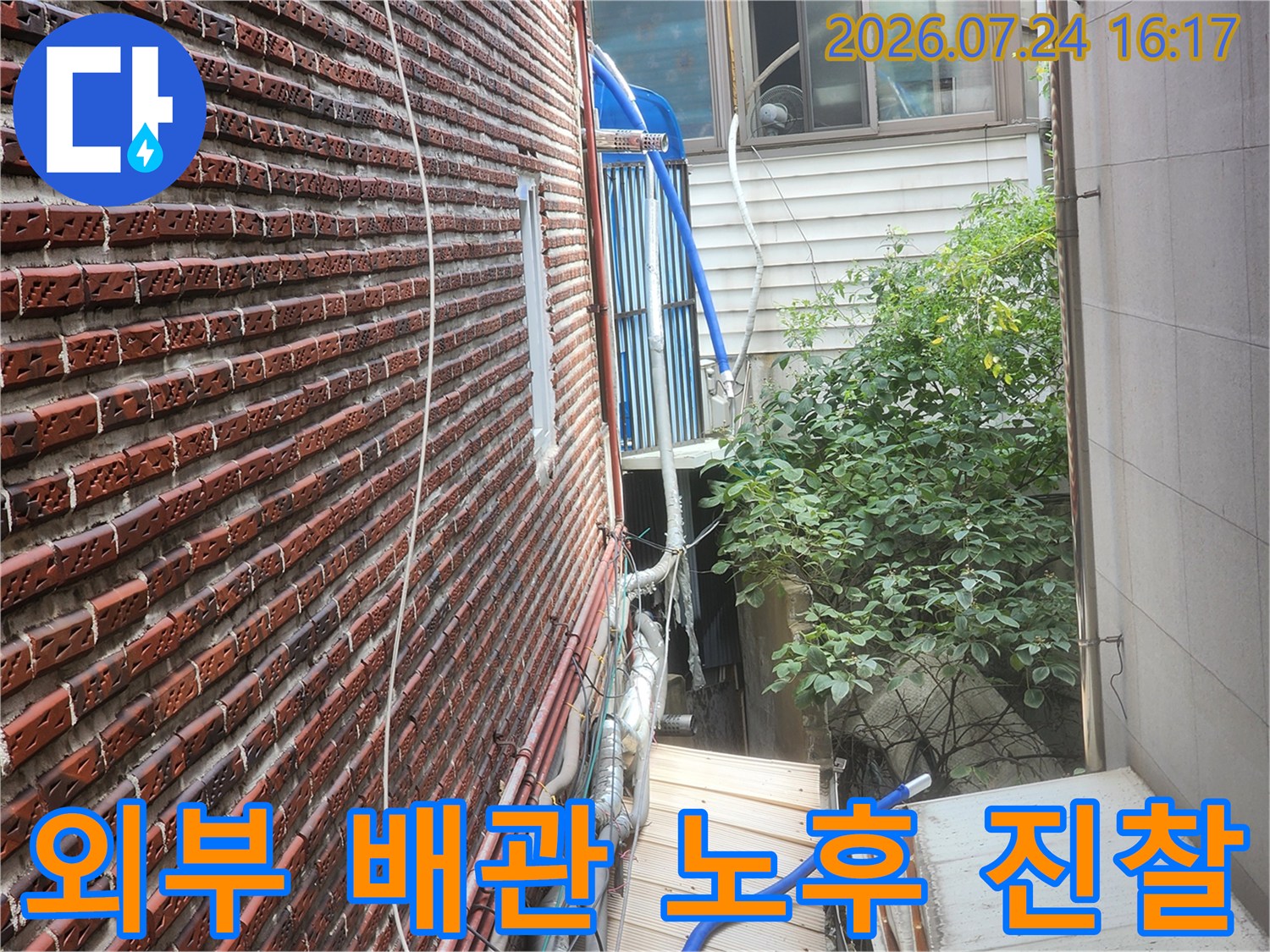 벽돌 벽면과 인접한 다양한 단열재로 마감된 수도 배관 시설물