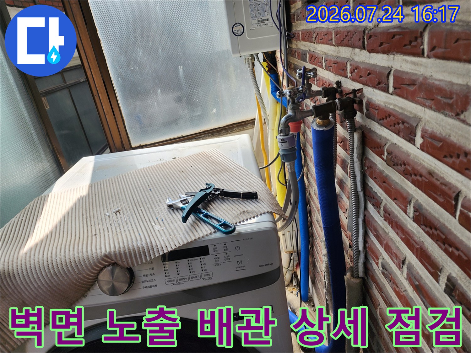 붉은 벽돌벽과 인접한 세탁실 내의 수도 및 가스 관련 배관 시스템 점검 모습
