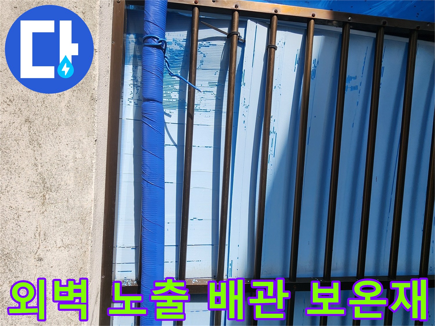 외부 벽면에 설치된-파란색 보온재로 감싸진-노출 배관의 모습