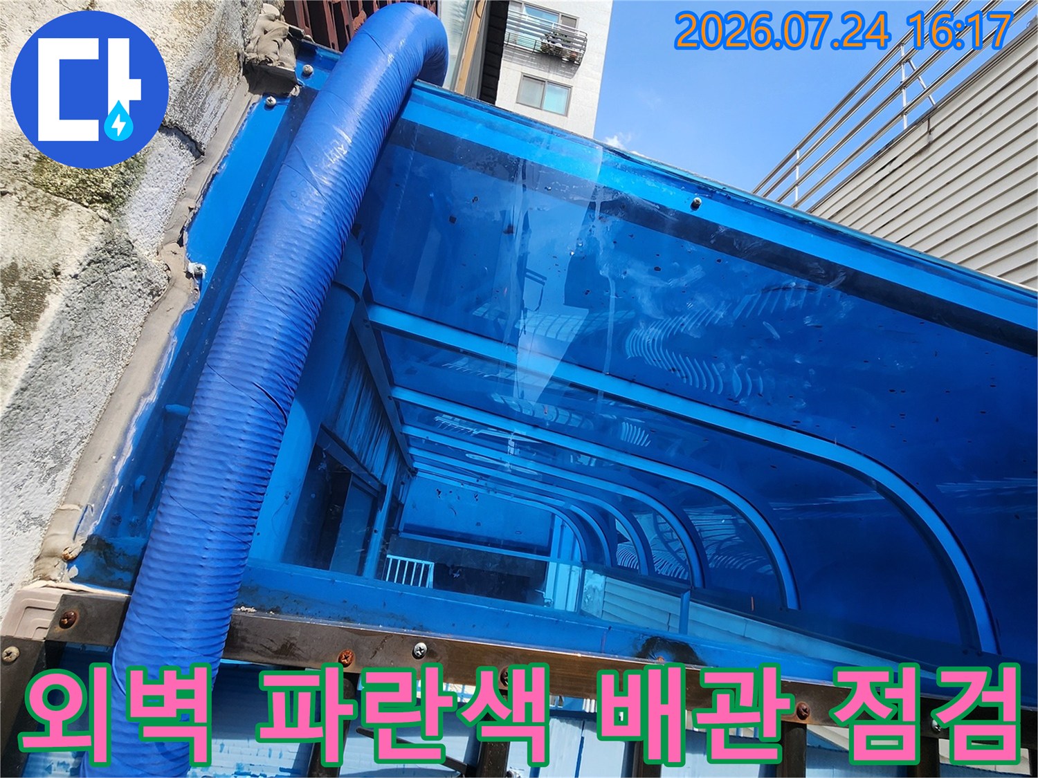파란색 보온재로 마감된 외부 노출 배관의 상태를 정밀하게 점검하는 모습
