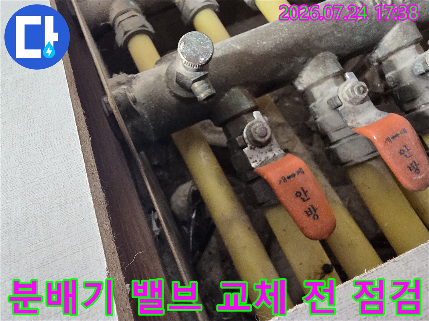 오렌지색 라벨과 배관이 연결된 분배기 시스템의 상세 모습