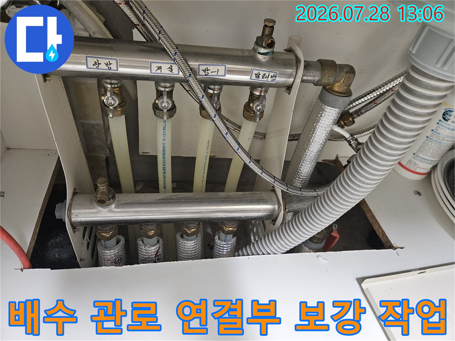 싱크대 하부에 설치된 배수 호스와 금속관의 접합부를 정밀하게 점검하는 모습