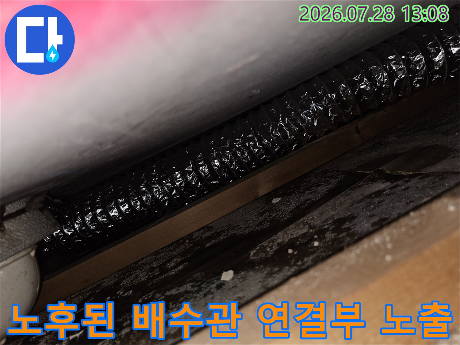 어두운 공간 속에 위치한 굴곡진 형태의 주방 배수 호스