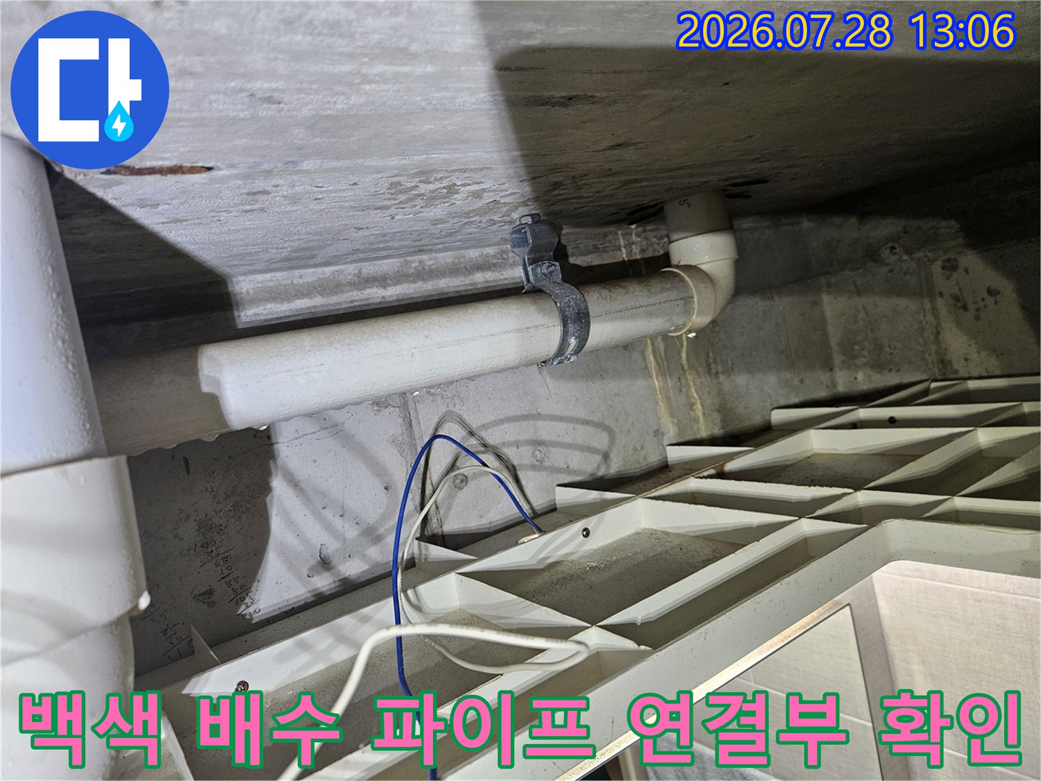 흰색으로 칠해진 하수 배관의 연결 지점과 고정용 장치