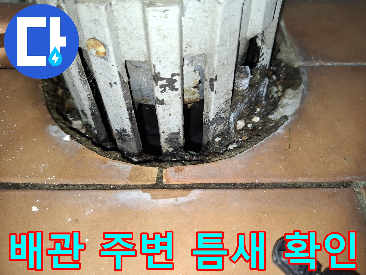 화장실 배관과 타일 사이의 틈새 및 오염 상태를 보여주는 사진입니다.