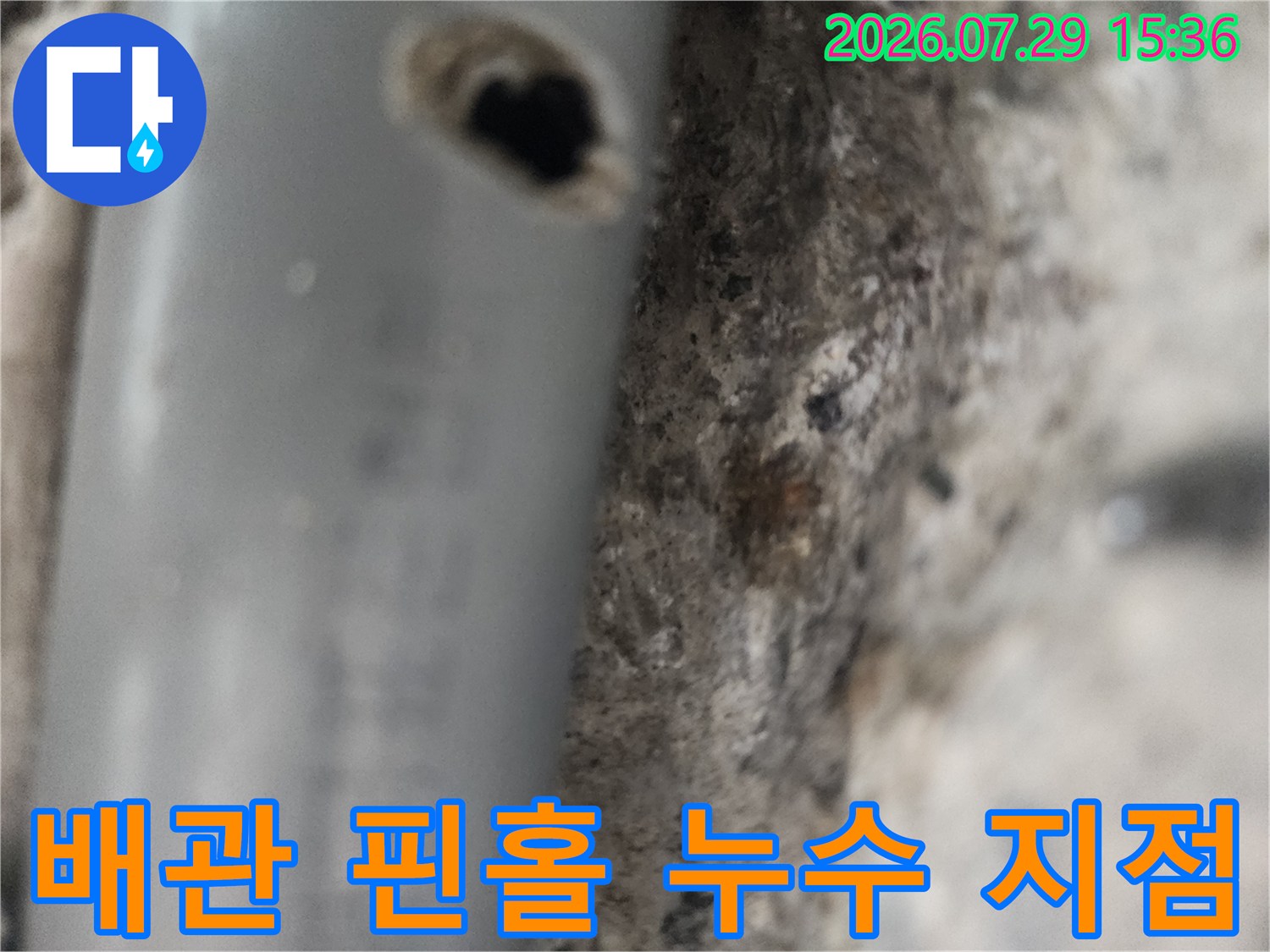 그레이톤 배관에 발생한 작은 구멍과 주변의 거친 벽면 자재
