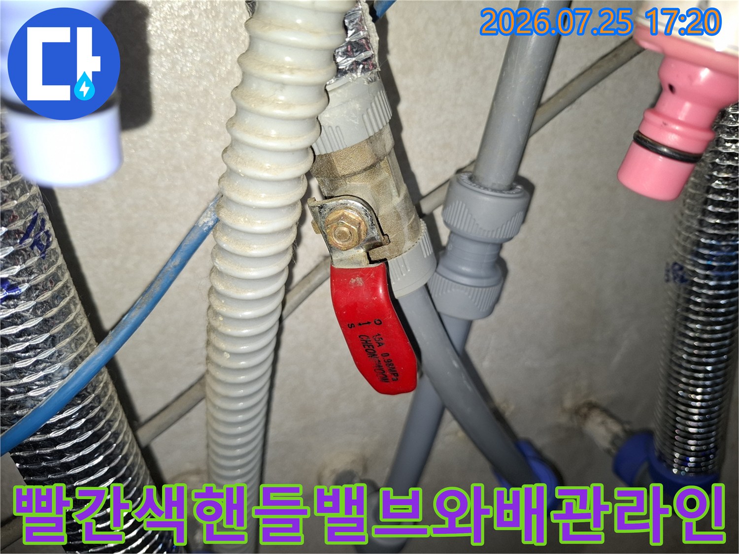 복잡하게 연결된 회색 배관과 빨간색 제어 밸브의 모습