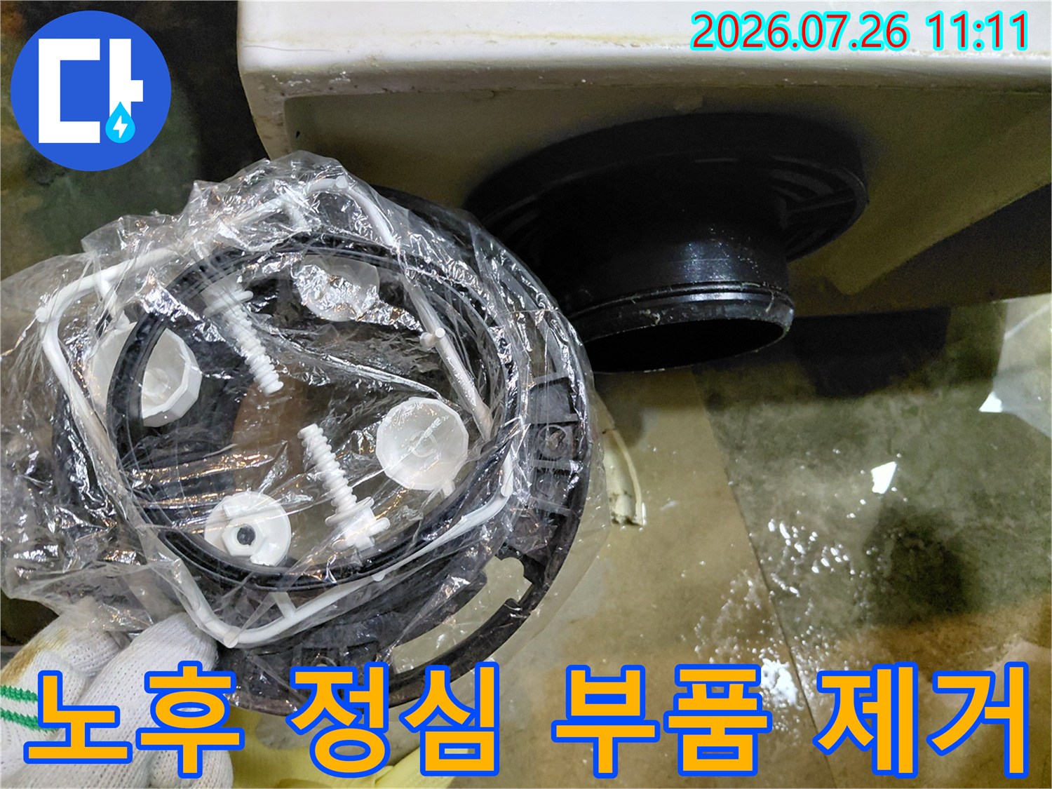 변기 하부의 낡은 배수 연결용 정심을 들어내고 교체 준비를 하는 모습