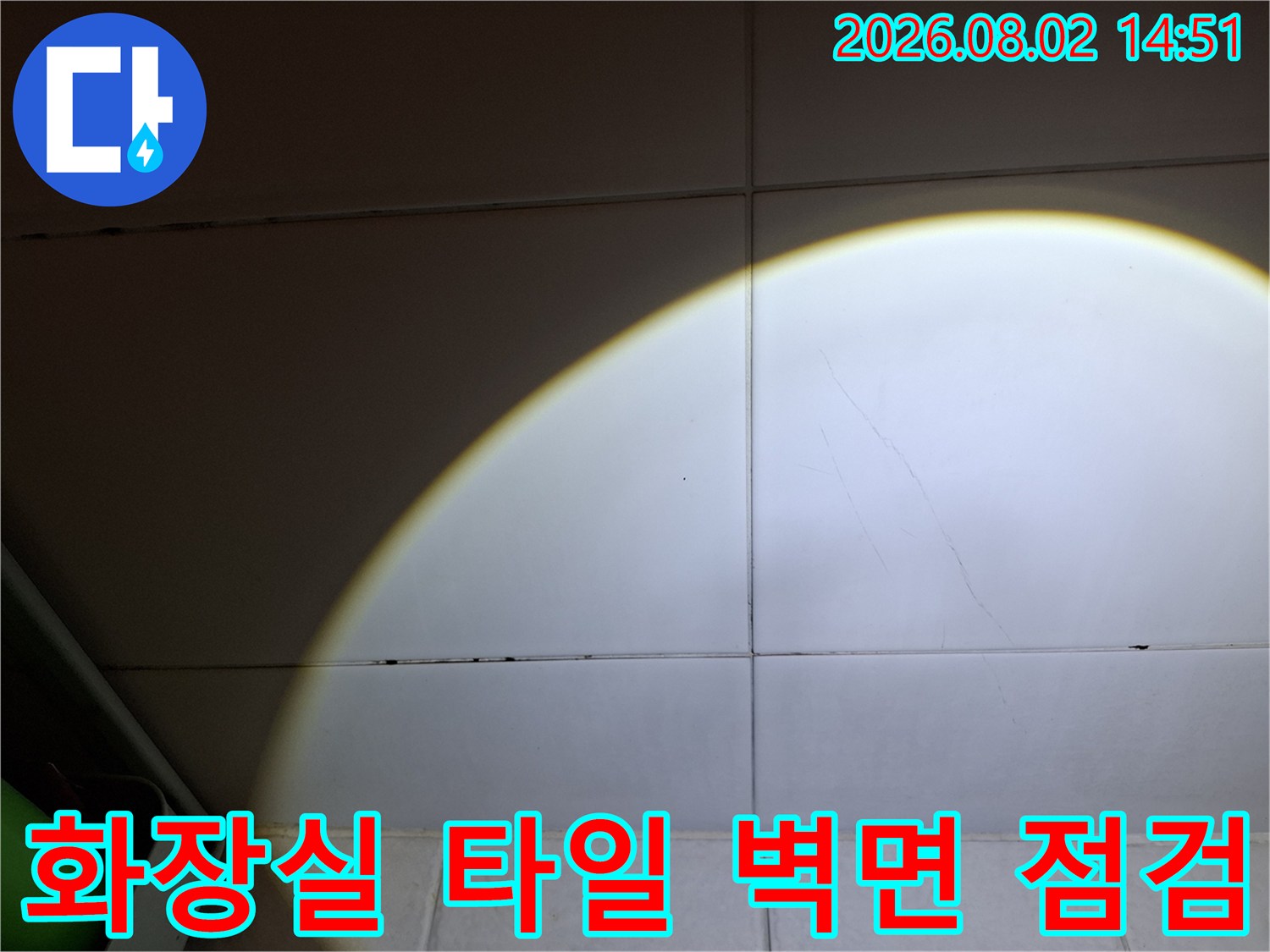화장실 타일 벽면에 비춰진 누수 진단용 조명과 균열 부위