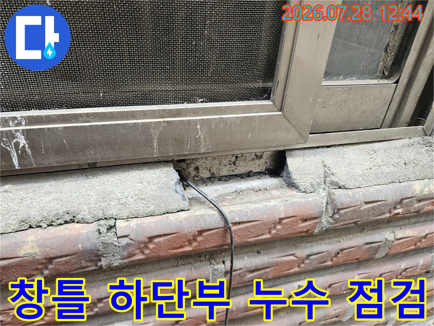 창틀 아래쪽 콘크리트 노출 부위와 배관을 점검하는 모습