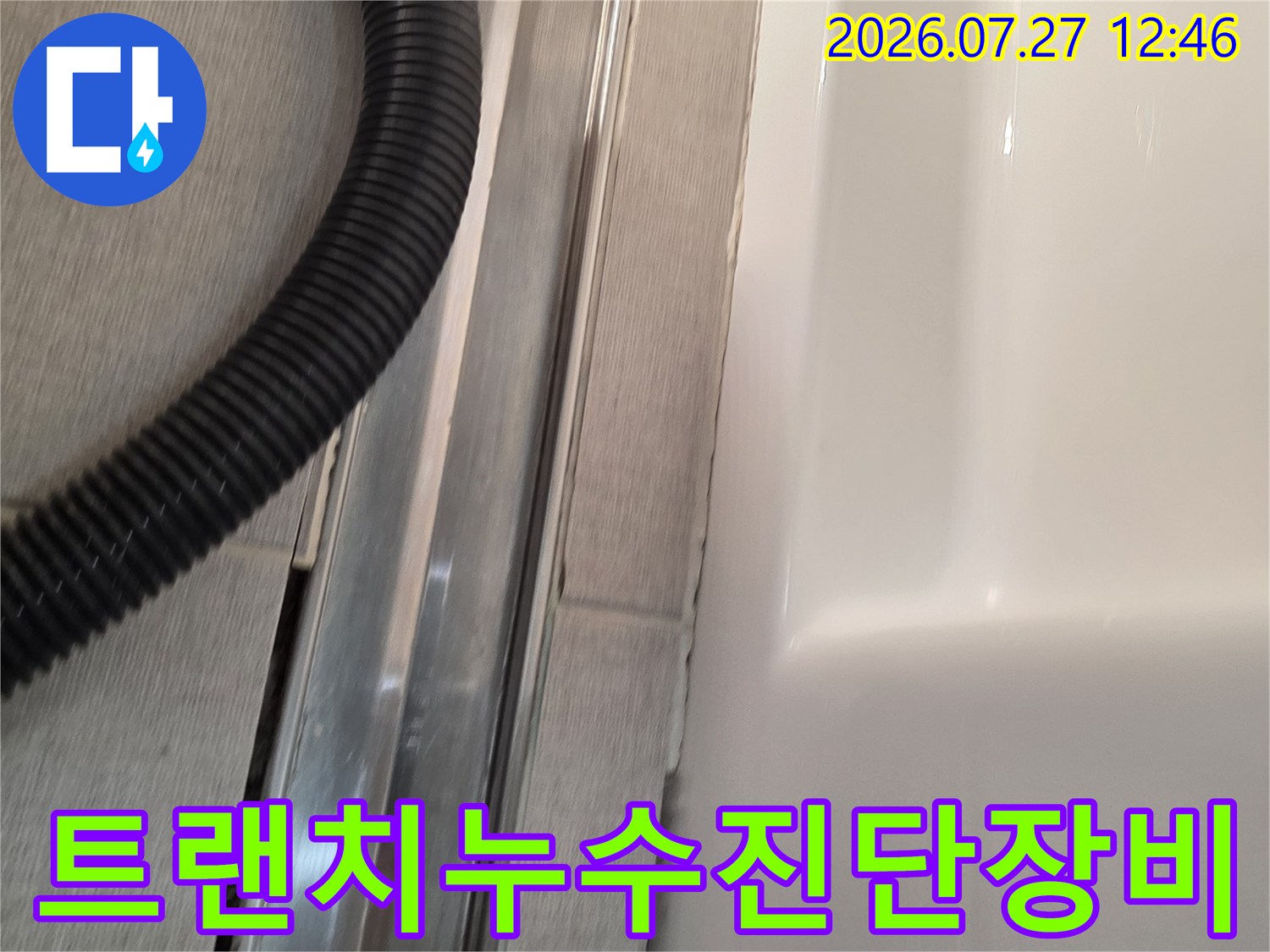 욕실의 금속제 트랜치 배수구-내부 점검을 위한 내시경 카메라 장비가 함께 찍힌 사진