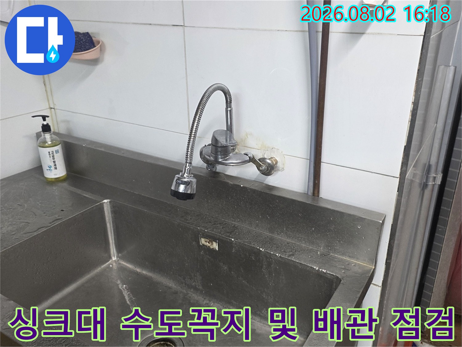 스테인리스 싱크대에 설치된 수도꼭지와 주변 타일 벽면 상태