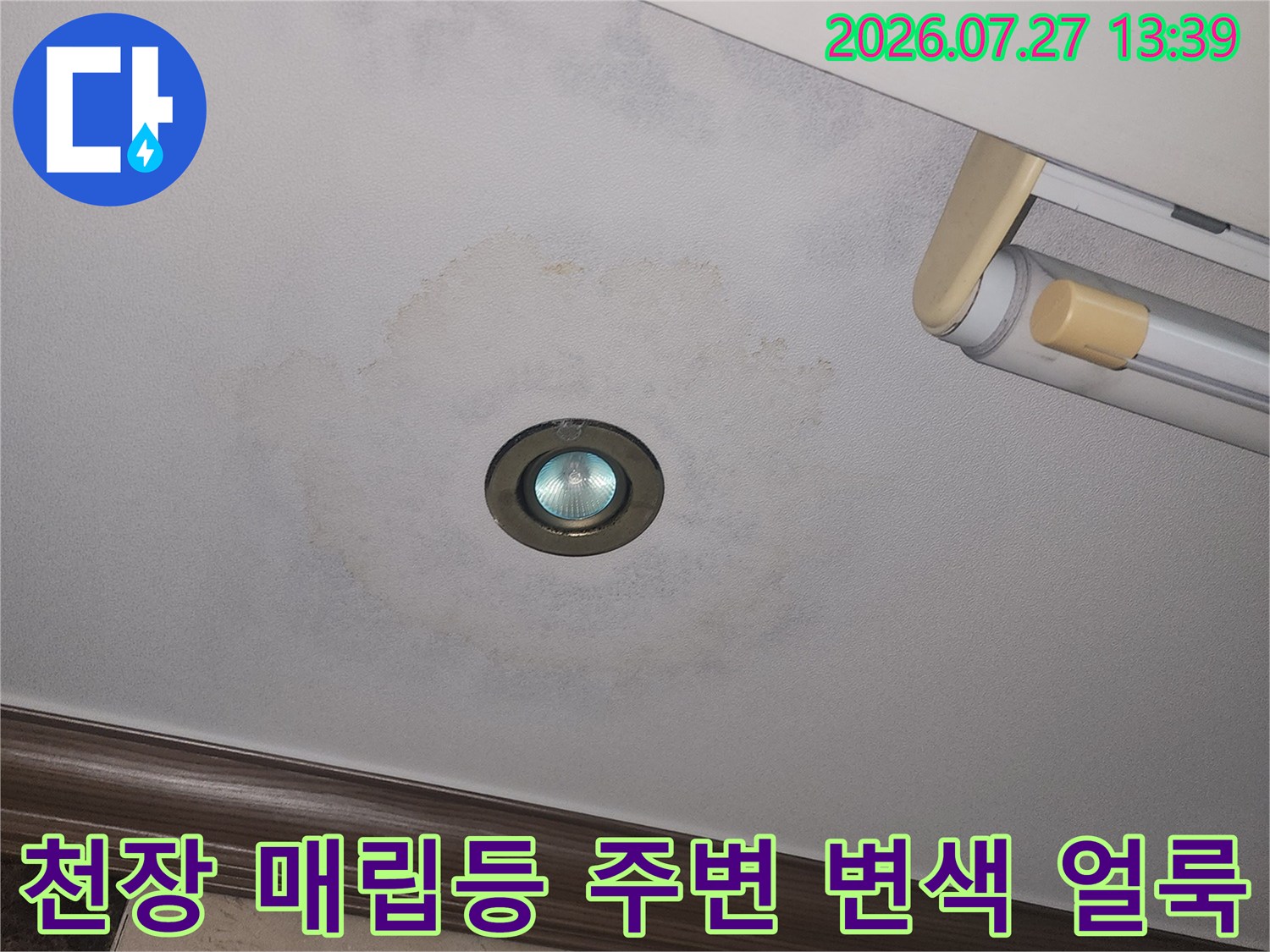 거실 천장의 매립형 조명 주변으로 물이 스며들어 발생한 둥근 모양의 누수 얼룩-사진